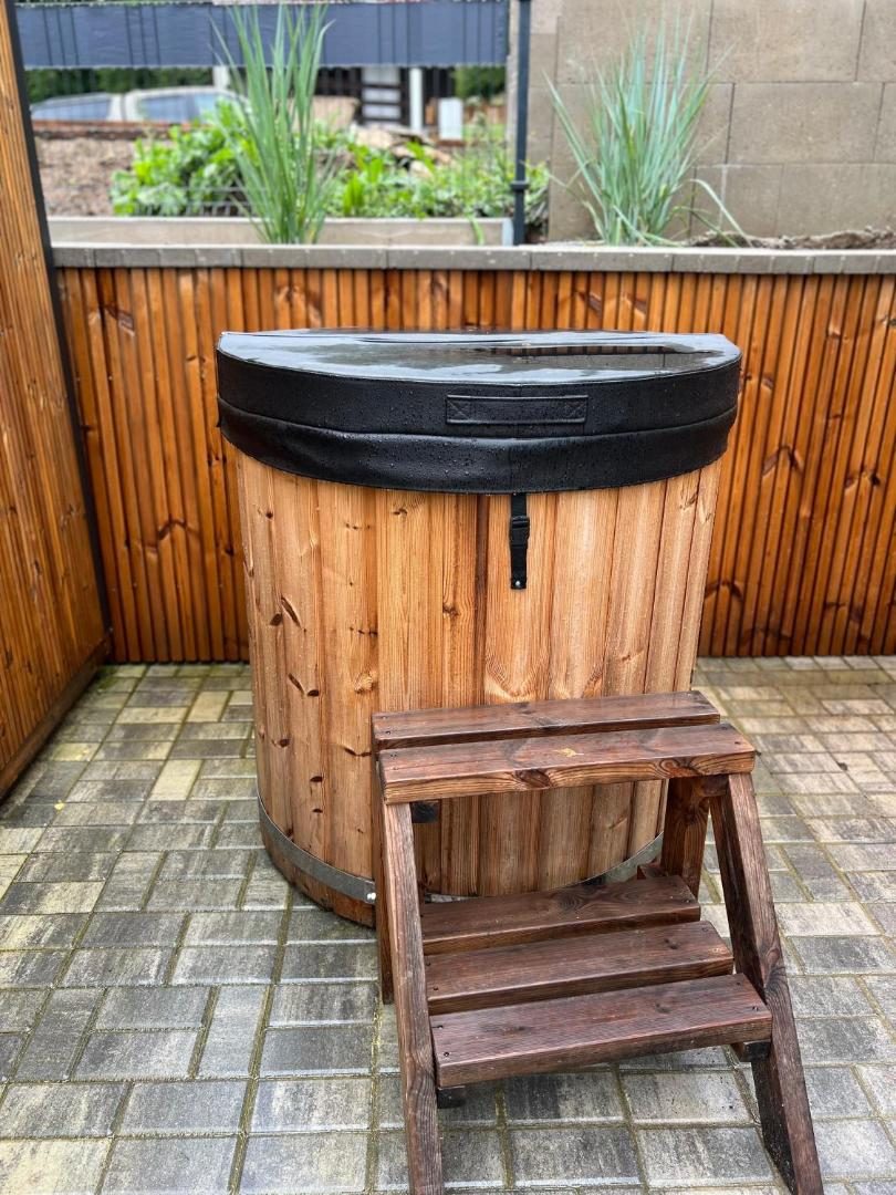 Dřevěná káď se schůdky na dlážděném posezení